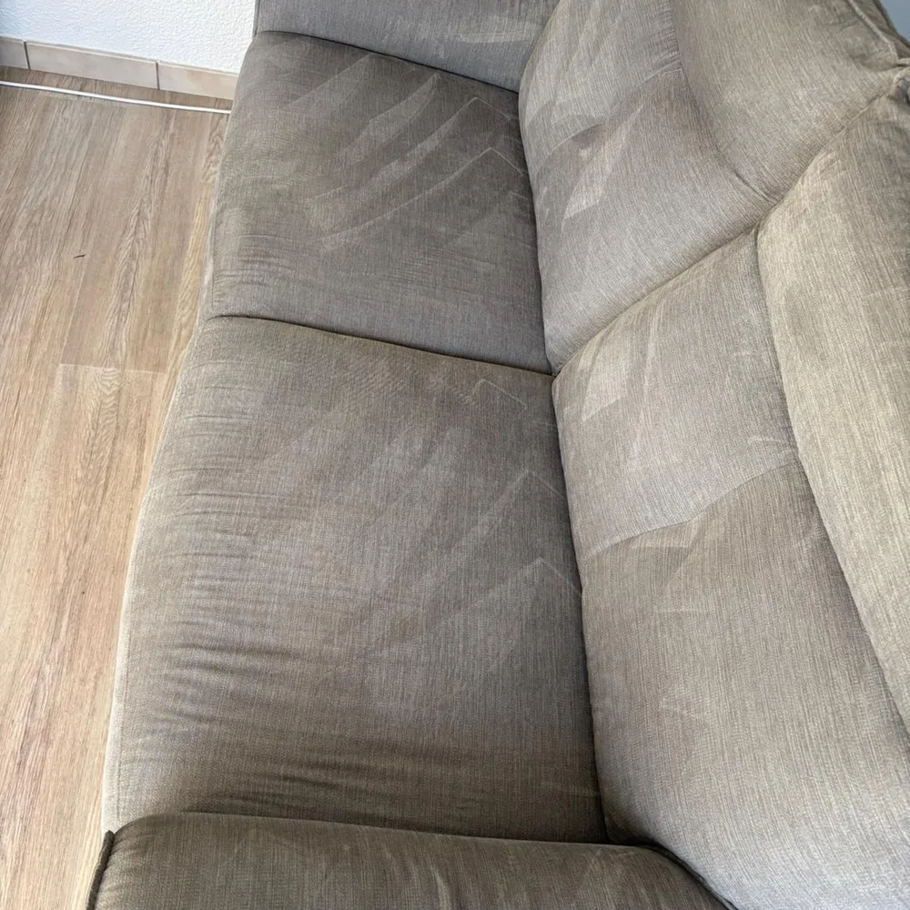 Canapé en tissu beige ravivé après traitement en profondeur