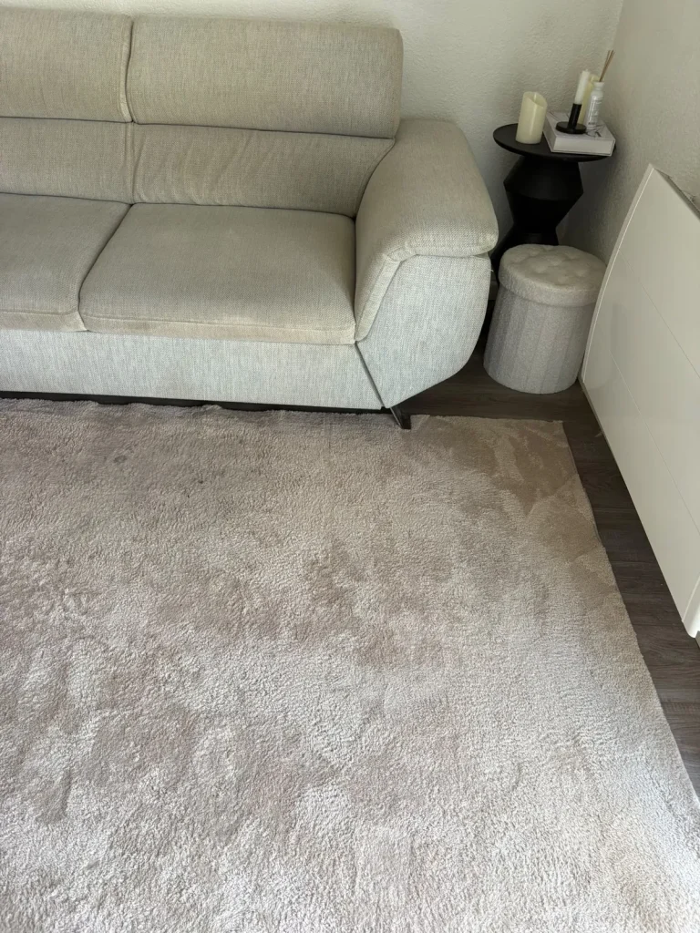 Canapé écru et tapis gris impeccables après nettoyage à domicile