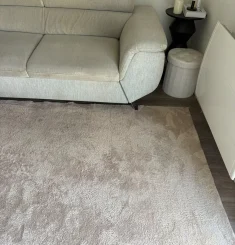 Canapé écru et tapis gris impeccables après nettoyage à domicile